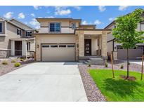 Beautiful two-story home featuring a two car garage and stone pillar accents at 9266 Telluride Ct, Commerce City, CO 80022