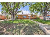 Charming brick home with a well-manicured lawn and mature trees offering great curb appeal at 9221 High St, Thornton, CO 80229