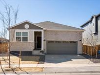 Inviting single-story home boasts a brick exterior and attached two-car garage at 6092 Corral St, Brighton, CO 80601