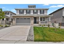 Charming two-story home featuring a brick-accented garage, covered porch, and well-manicured lawn at 7325 S Waterloo Way, Aurora, CO 80016