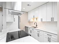 Modern kitchen with white cabinets, quartz countertops, and stainless steel appliances at 5691 W 35Th Ave # 2B, Wheat Ridge, CO 80212