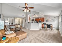 Open-concept living room featuring vaulted ceilings, plush seating, and a seamless flow into the kitchen and dining areas at 1425 Blue Sky Cir # 15-301, Erie, CO 80516