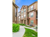 View of the townhomes showing the manicured lawn and path to the homes at 2225 Santini Trl # C, Littleton, CO 80129