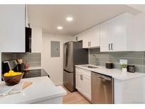 Modern kitchen featuring stainless steel appliances, white cabinetry, and sleek countertops at 8335 Fairmount Dr # 7-208, Denver, CO 80247