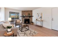 Inviting living room with stone fireplace, stylish decor, and abundant natural light at 8335 Fairmount Dr # 7-208, Denver, CO 80247