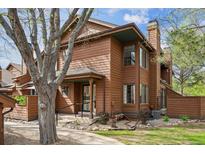 Charming brown two-story home featuring mature trees and professional landscaping at 8095 Garrison Ct # B, Arvada, CO 80005
