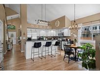 Bright and modern kitchen with white cabinets, black hardware and hardwood floors at 8051 W 78Th Cir, Arvada, CO 80005