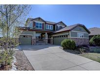 Charming two-story home with a three car garage, stone accents, and well-manicured landscaping at 11918 S Hitching Post Trl, Parker, CO 80134
