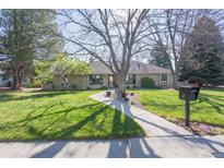 Charming brick home with a well-manicured lawn, mature trees and a welcoming walkway to the front door at 2 Larkdale Dr, Littleton, CO 80123