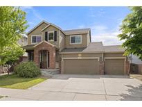 Charming two-story home with a three car garage, brick accents, and covered entry at 41 Jordan Ln, Erie, CO 80516