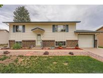 Charming home with a well-maintained lawn, brick accents, and inviting curb appeal at 744 Memphis St, Aurora, CO 80011