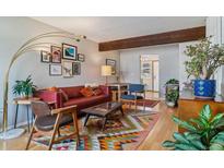 Cozy living room with a colorful rug, modern lighting, and a comfortable red leather sofa at 1531 S Owens St # 23, Denver, CO 80232