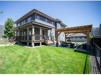 Inviting backyard featuring a pergola-covered dining area, spacious lawn, and a two-story deck at 4180 Kalamath St, Denver, CO 80211