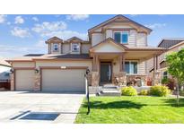 Charming two-story home featuring a two-car garage and inviting front porch at 802 Gamble Oak St, Brighton, CO 80601
