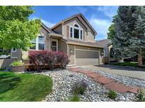 Charming exterior of a two-story home with a well-manicured lawn and stone walkway at 8258 S Reed Way, Littleton, CO 80128