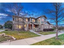 Charming two-story home with stone accents, covered porch, landscaped yard, and inviting curb appeal at 10459 Rivington Ct, Lone Tree, CO 80124