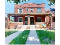 Charming brick duplex with a shared front porch and well-maintained lawn at 126 S Clarkson St, Denver, CO 80209