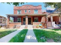 Charming brick duplex featuring a covered front porch and well-maintained lawn at 126 S Clarkson St, Denver, CO 80209