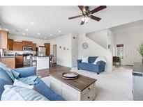 Inviting living room with hardwood floors, a ceiling fan, and an open layout leading to the kitchen at 5536 Kirk St, Denver, CO 80249