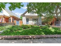 Charming two-story home with a well-manicured lawn and inviting front porch at 623 S Logan St, Denver, CO 80209