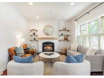 Cozy living room showcasing a fireplace, hardwood floors, and stylish furniture with bright, natural light at 623 S Logan St, Denver, CO 80209