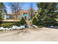 Charming brick two-story home with mature trees and an inviting entrance at 4 Prairie Falcon Ln, Littleton, CO 80127