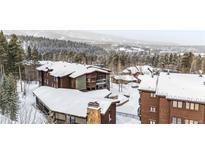 Ski condos with snow-covered roofs nestled amidst pine trees and mountains at 290 Broken Lance Dr # B202, Breckenridge, CO 80424