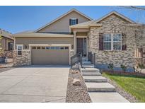 Charming two-story home with a manicured lawn and a two-car garage with a concrete driveway at 7693 S Quantock Way, Aurora, CO 80016