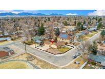 Stunning aerial view of the home with mountain views, solar panels, and a spacious front yard with mature trees at 6545 Union St, Arvada, CO 80004