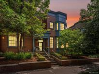 Charming brick home with landscaped front yard, covered porch, and blue trim under a colorful sky at 8450 E 29Th Ave, Denver, CO 80238