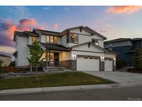 Beautiful two-story home featuring a spacious three-car garage and welcoming covered front porch at 6696 Kenzie Cir, Castle Pines, CO 80108