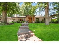 Charming single-story home with a landscaped yard and inviting front entry with a classic stone walkway at 909 S Monroe St, Denver, CO 80209