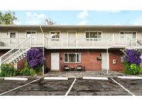 Apartment building featuring brick facade, painted stairs and railings, and charming purple flowers at 3705 Quail St # 4, Wheat Ridge, CO 80033