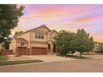 Beautiful two-story home featuring a three-car garage, a basketball hoop, and a well-manicured lawn at 10995 Quintero St, Commerce City, CO 80022