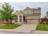 Charming two-story home with stone accents, solar panels, well-maintained lawn, and an attached two-car garage at 13351 Olive Way, Thornton, CO 80602