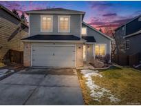 Charming two-story home featuring a gray exterior, brick accents, attached garage, and well-maintained lawn at 758 Poppywood Pl, Highlands Ranch, CO 80126