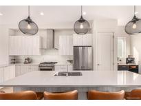 Modern kitchen features stainless steel appliances, pendant lighting, and a center island with seating at 4335 N Pecos St, Denver, CO 80211