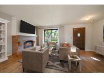 Comfortable living room with modern furnishings, a brick fireplace, and a large window at 14735 W Ellsworth Ave, Golden, CO 80401