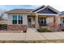 Charming home with stone accents and a welcoming front porch swing, perfect for relaxing outdoors at 19820 W 57Th Ln, Golden, CO 80403