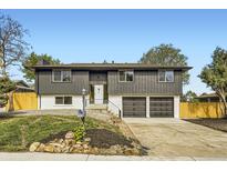 Charming split-level home with a well-manicured lawn, two-car garage, and neutral tones at 6876 Quay Ct, Arvada, CO 80003