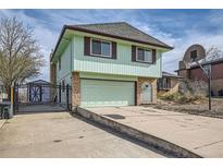 Two story home featuring brick accents, a two-car garage, and a basketball hoop at 16463 E Girard Ave, Aurora, CO 80013