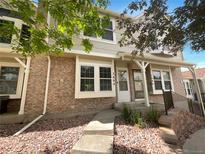 Charming townhome exterior with brick facade and a well-maintained front yard with rock covering at 7604 S Steele St, Centennial, CO 80122