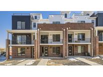 Modern brick townhome exterior with private balconies and walkway at 9637 Browns Peak Cir, Littleton, CO 80125