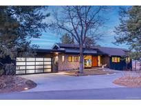 Stunning modern exterior showcasing a unique stone facade and a glass-paneled garage door at 14815 Foothill Rd, Golden, CO 80401