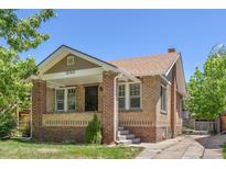 Charming brick home featuring a covered front porch and well-maintained landscaping at 2140 S Washington St, Denver, CO 80210