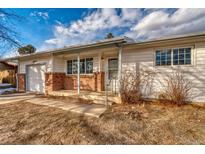 Ranch-style home with brick accents and a covered porch at 13643 E Exposition Ave, Aurora, CO 80012