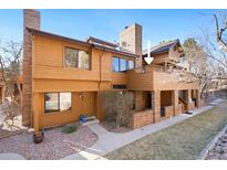 Inviting two-story townhouse featuring a private balcony, warm wood siding, and well-maintained landscaping at 9400 E Iliff Ave # 37, Denver, CO 80231