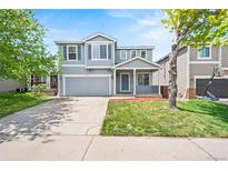 Charming two-story home with a well-maintained lawn and inviting front porch at 9753 Gatesbury Cir, Highlands Ranch, CO 80126