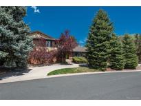 Charming two-story home with landscaped yard and inviting curb appeal, surrounded by mature trees and a well-maintained lawn at 5361 Nassau Cir, Cherry Hills Village, CO 80113
