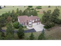 Beautiful home featuring a two car garage surrounded by lush greenery at 7641 Kelty Trl, Franktown, CO 80116